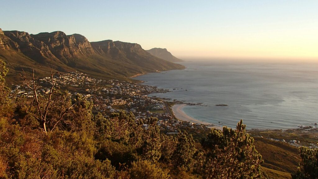 Beautiful panoramic view of Cape Town's coastline with mountains and ocean during sunset.